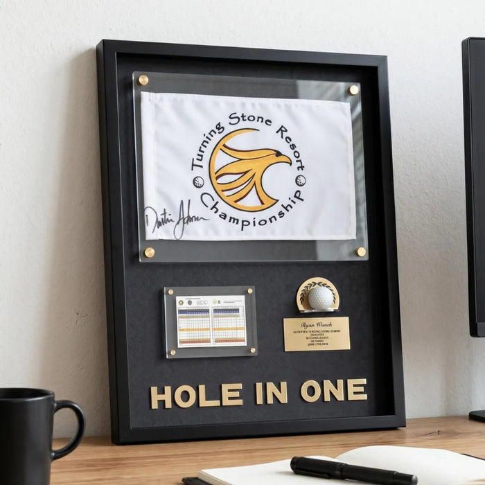 Framed 'Hole in One' golf item with Turning Stone Resort Championship logo on a desk.